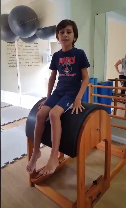 Criança sentada em um aparelho de pilates