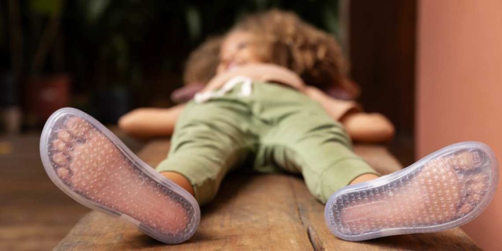 criança usando um calçado com sola transparente para mostrar como fica a posiçõa dos dedos em um calçado barefoot.